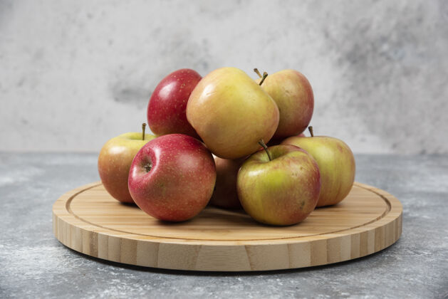 食物一堆新鲜成熟的苹果放在木板上多汁生的红色