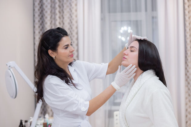 专业客户在美容师的预约 咨询 面部整形 准备即将进行的程序 目视检查的问题领域美容师过程女人