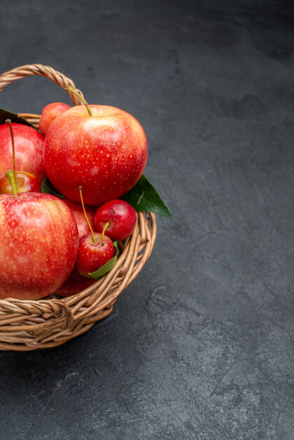 壁板侧面特写拍摄水果开胃的樱桃和苹果 篮子里有叶子成熟吃苹果水果