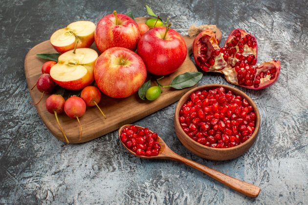 石榴苹果一碗石榴樱桃苹果放在砧板上碗壁板草莓