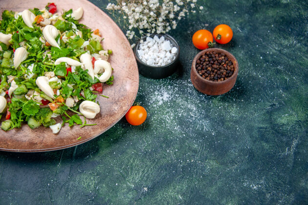 食物前视图蔬菜沙拉内优雅的深蓝色背景板晚餐胡椒蓝色