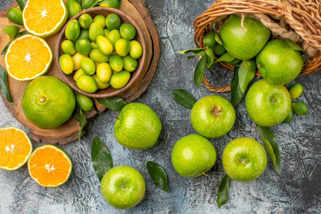 酸橙顶部特写镜头苹果柑橘类水果在板上绿色的苹果与树叶在篮子里板绿色篮子