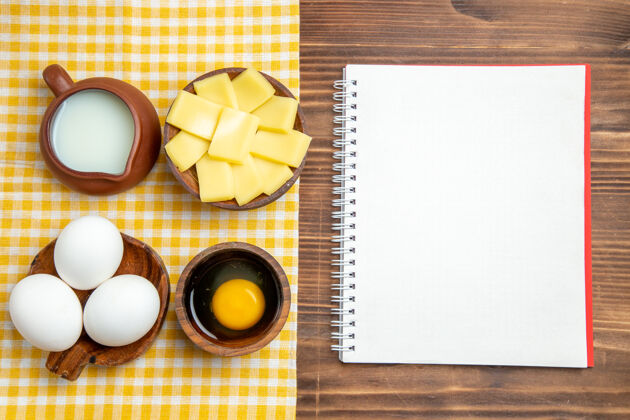 鸡蛋顶视图生鸡蛋与奶酪和牛奶在木制表面产品蛋面团餐食品生牛奶餐玻璃杯