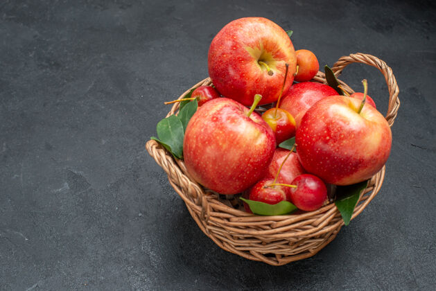 樱桃侧面特写镜头可以看到水果篮里的开胃苹果和樱桃多汁篮子吃苹果