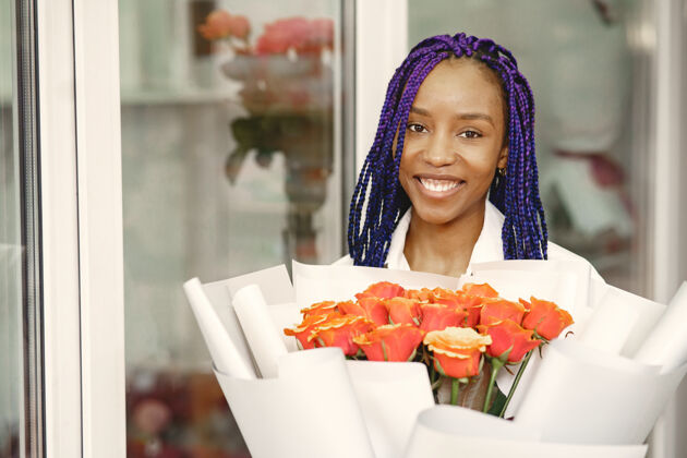 花卉站在工作场所的女经理手里拿着植物的女士花店中心的快乐女花店花店理念女孩自然花卉