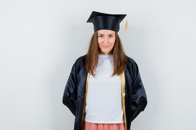 背部女毕业生手挽着制服 穿着休闲服 面带羞耻 前仰后合大学手帽子
