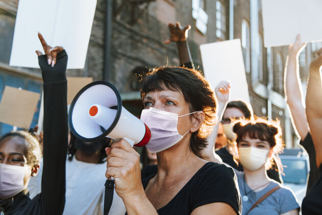 女权主义戴着口罩的不同人群在covid-19大流行期间抗议权利外面