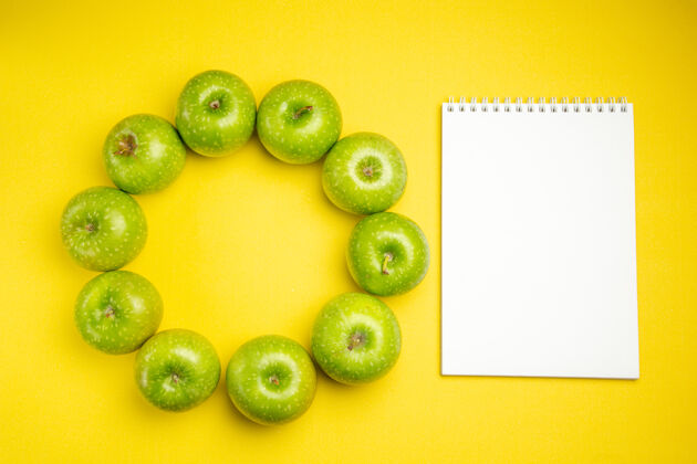 有机苹果俯视图绿色苹果旁边的白色笔记本笔记本苹果食品