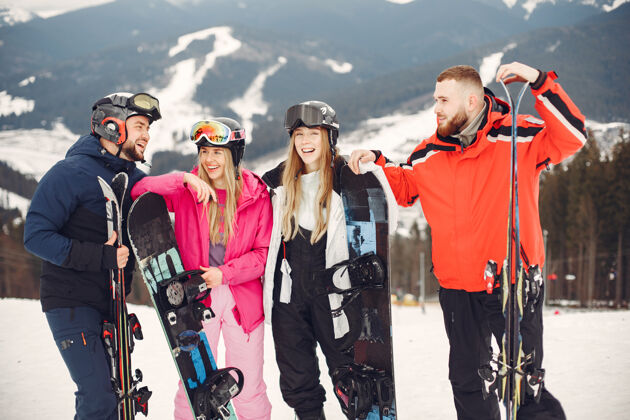 高山穿着滑雪板套装的朋友在山上玩滑雪板的人在地平线上手拿滑雪板的人关于运动的概念寒冷胡须红色
