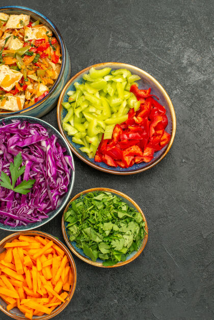 地板顶视图不同的蔬菜切片与鸡肉沙拉在黑暗的地板健康沙拉饮食蔬菜一餐食物