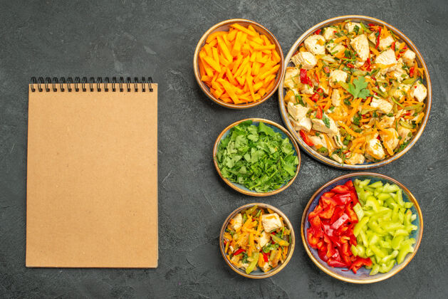 鸡肉沙拉俯视图鸡肉沙拉与蔬菜和蔬菜在黑暗的餐桌上饮食沙拉健康饮食盘子胡椒粉