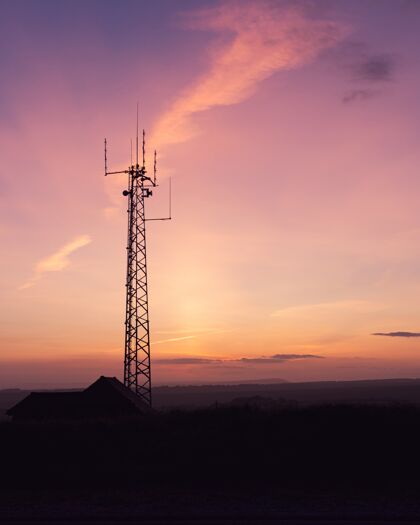 传输垂直拍摄的电信塔在一个领域下惊人的天空-完美的墙纸高垂直建筑
