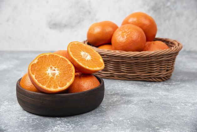 圆形石桌上摆满了橙子汁的木碗柑橘味道多汁