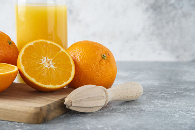甜点在木板上放一个装有橙子切片的果汁的玻璃罐成熟果汁纯