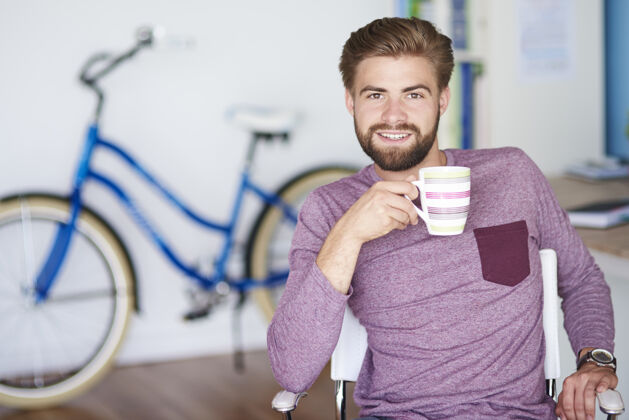 男士蓝色的自行车旁边有个快乐的男人咖啡工作场所年轻人