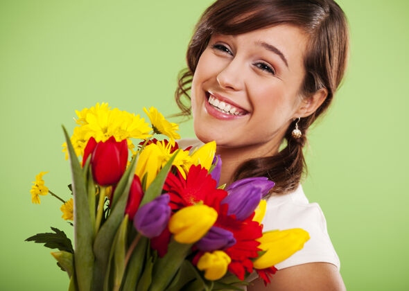 女人一个带着五颜六色花朵的微笑女人的肖像切花成人室内