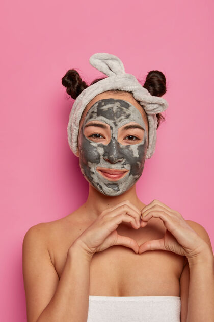 水疗Spa民族妇女脸上戴着美容面膜 在身体上塑造心灵 表达爱意 洗澡后做除皱程序 隔离在玫瑰色的墙壁上美丽和健康的概念头带高兴结