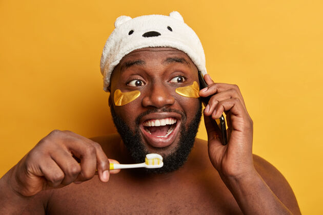 贴片年轻的黑人男子刷牙 讲智能手机 贴胶原蛋白贴片蛀牙成人清洁