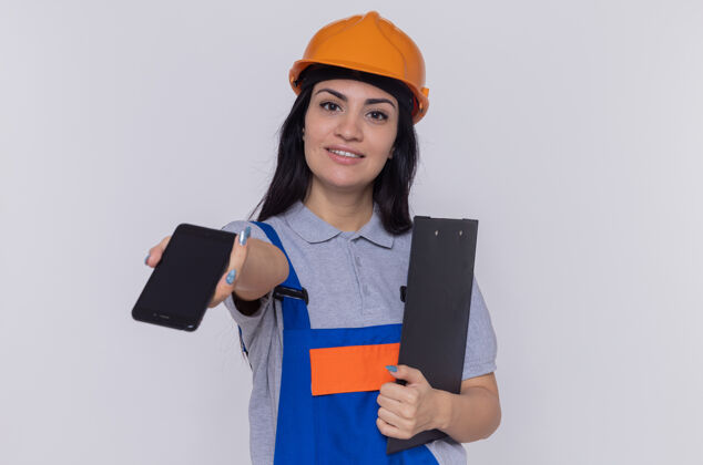 剪贴板穿着施工制服和安全帽的年轻建筑工人建筑商年轻信心