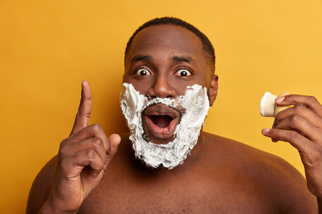 肌肉非裔美国男人在脸颊上涂剃须膏尖锐胸部男人
