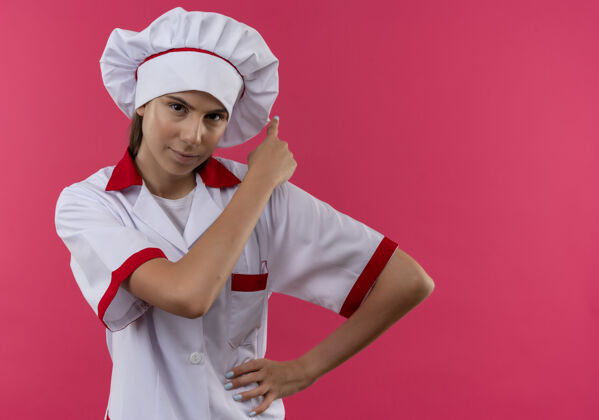 背部年轻自信的白人厨师女孩穿着厨师制服点着背孤立的粉色空间与复印空间复制女孩厨师