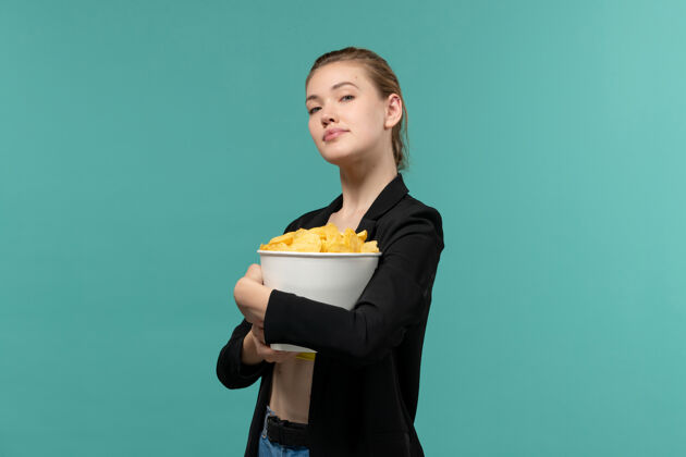 电影正面图年轻女性在蓝色的水面上吃薯片看电影女商人专业人士企业家