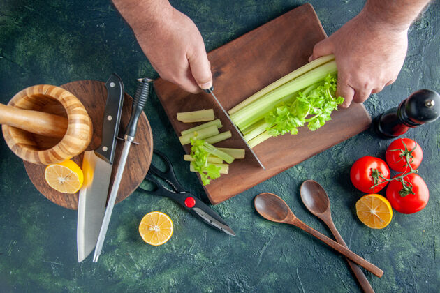 剪刀顶视图男厨师切芹菜深色餐桌沙拉减肥餐彩色照片食物健康钢顶颜色