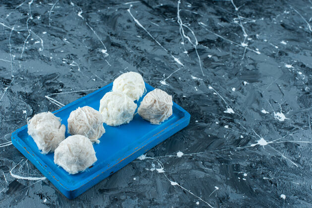 棉花糖美味的土耳其棉花糖放在木制盘子里 蓝色背景传统美味美味
