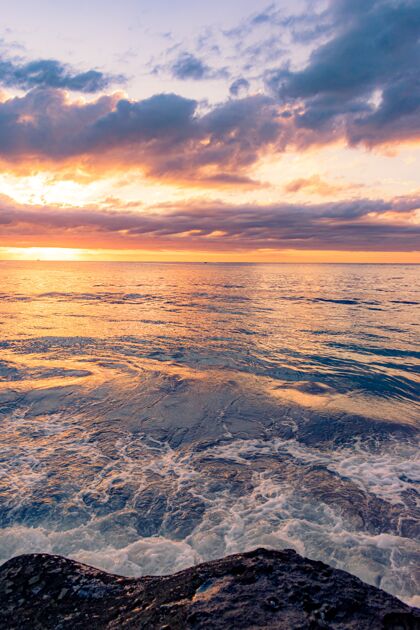 海岸在美丽的日落背景下 岩石海滩的迷人景色黎明黄昏放松