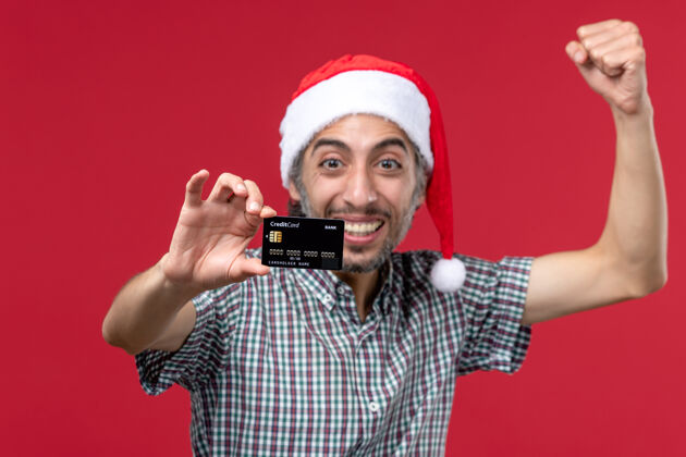 视图正面图：年轻男性在红色背景下展示银行卡卡片脸银行