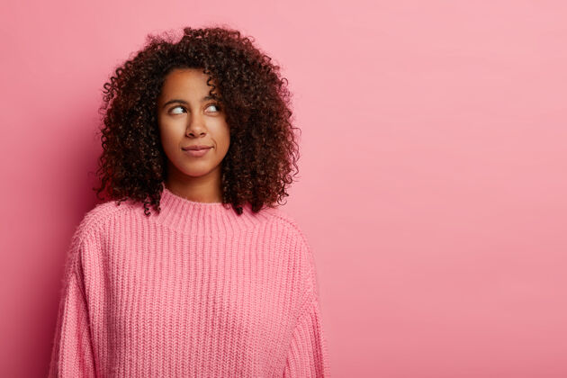 室内一个非洲女人思考问题 思考如何在困境中行动 穿着粉色针织毛衣站在室内发型非洲青少年
