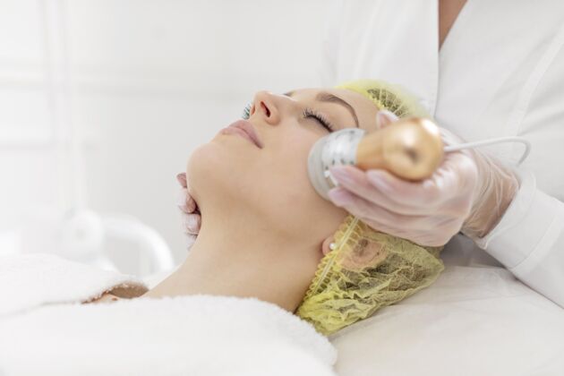 美容院在美容诊所做面部护理的女人面部按摩治疗客户