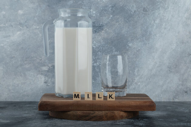 健康在木板上放一壶牛奶和一杯水字母新鲜透明