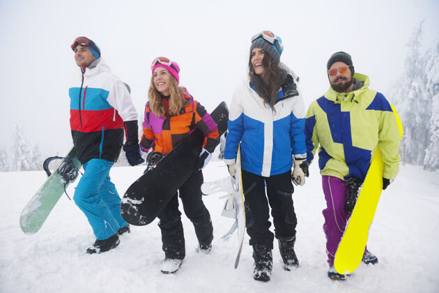 牙牙学语的微笑两对情侣在玩滑雪欢乐四个人运动