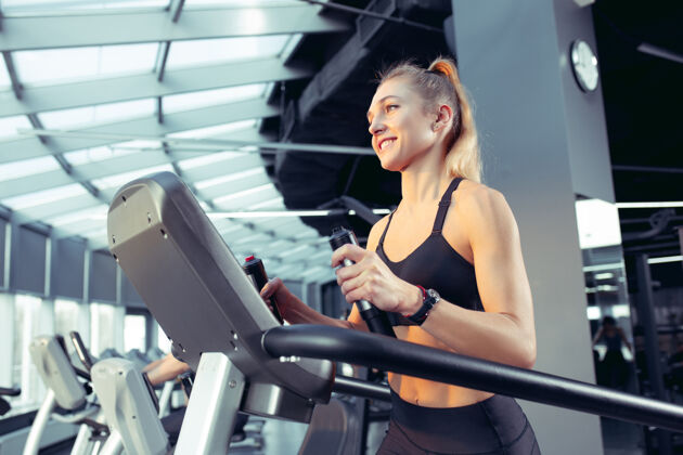 交叉年轻肌肉发达的白种女人在健身房练习 做有氧运动运动的女模特做力量练习 训练她的上身健康 健康的生活方式 健美的概念肌肉私人教练形状