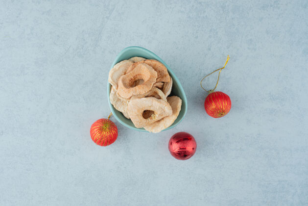 球一个蓝色的盘子装满了健康干果和圣诞红球高质量的照片美味苹果圣诞玩具