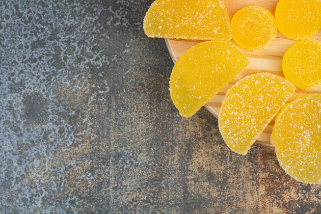 美味木制盘子上的黄色甜果冻糖果冻美味糖果