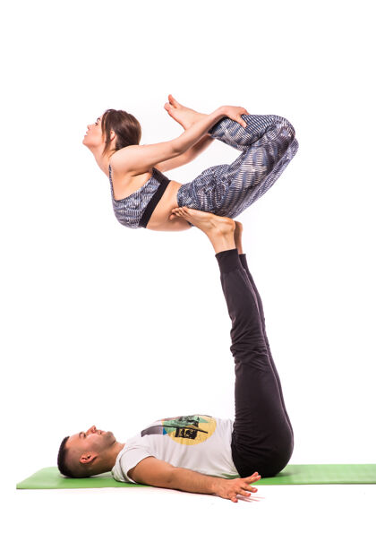 人类情侣在白色工作室练习acro瑜伽acro瑜伽概念双人瑜伽瑜伽柔韧性课程锻炼肢端瑜伽情侣力量