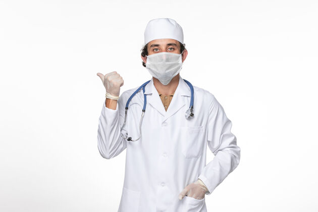 人正面图：男医生穿着医疗服 戴着口罩 以防白墙病毒溅起冠状病毒大流行大流行防护正面