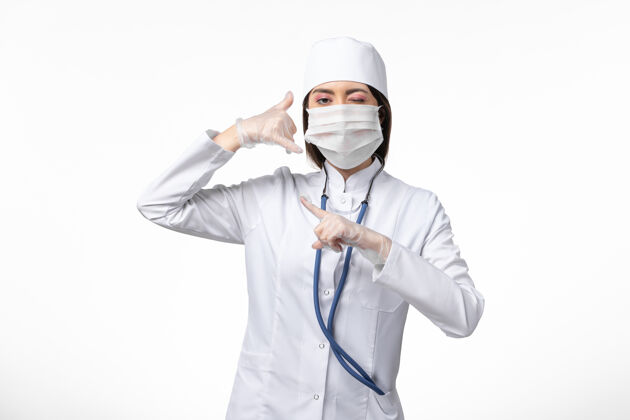 人员正面图女医生身穿白色无菌医疗服 带口罩 因冠状病毒轻染白墙大流行性疾病冠状病毒灭菌医疗病毒