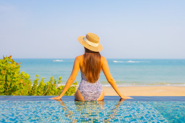 人美丽的年轻女子在泳池上放松的画像帽子假日夏天