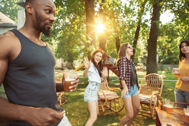 工艺一群快乐的朋友在阳光明媚的日子里喝着啤酒 一起烧烤一起在户外的林间空地或后院休息友谊休闲自然