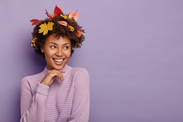 旁白积极的美国黑人女士 秋叶卷发 浆果成熟 穿着紫色针织毛衣 专注在一边 隔离在紫色的墙上 复制空间区域欢乐牙关欢呼