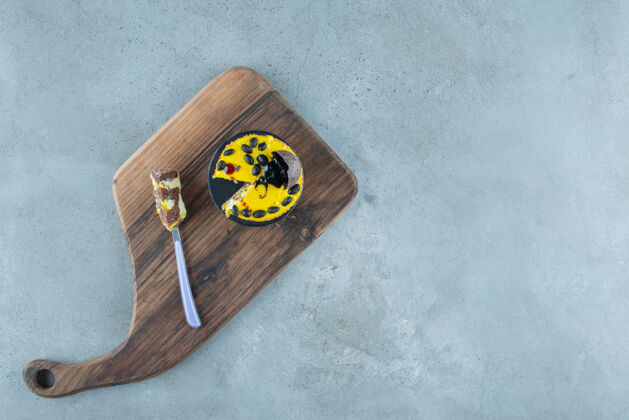 口感一个小蛋糕和一个叉子放在大理石背景的木板上高质量的照片叉子蛋糕餐盘