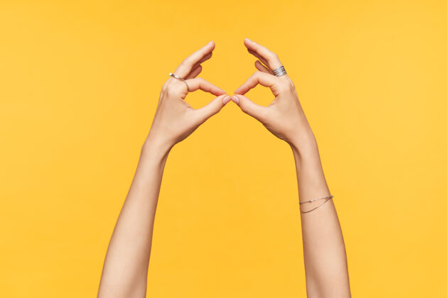 模仿年轻女性皮肤白皙的手被隔离在黄色背景下 用折叠的手指和眼镜模仿的侧视图手和肢体语言概念标志身体语言
