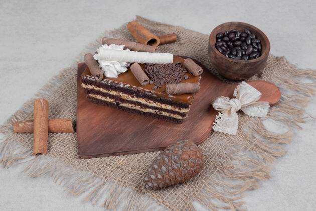 圣诞节一片巧克力蛋糕 肉桂和松果放在粗麻布上高质量的照片面包房甜点蛋糕