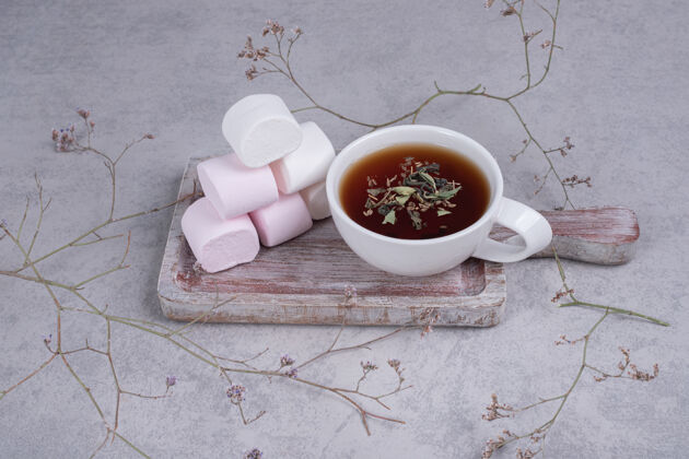 植物花草茶和一盘棉花糖在灰色背景上高质量的照片好吃的棉花糖杯子