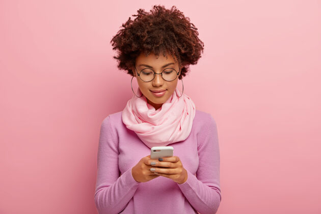 Rosie非洲发型美女横拍 用智能手机设备 集中在显示器上 发短信 连接无线上网脖子上戴紫色套头巾手机电话注意力