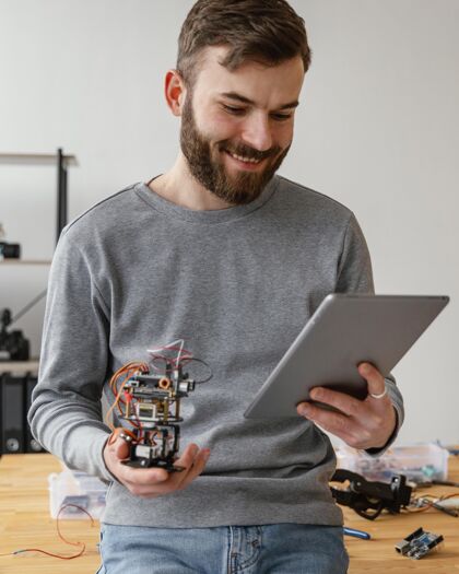 机器人拿着平板电脑的人在学习制造机器人平板电脑工艺技术