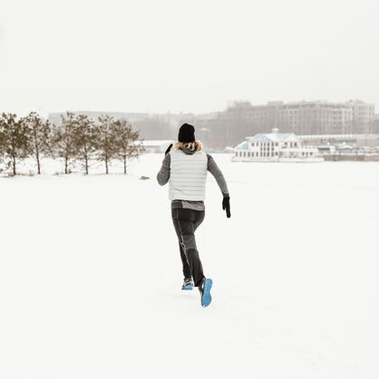 锻炼全副武装的人在雪中奔跑私人教练突破男人